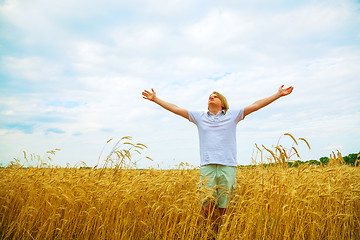 Image showing Young man staying with raised hands