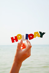 Image showing Female's hand holding colorful word 'Holiday'