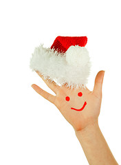 Image showing Human's palm with smile on it wearing Santa's hat