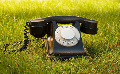 Image showing Retro styled rotary telephone on grass