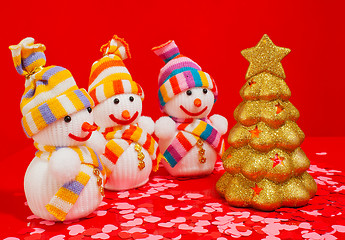 Image showing Three snowmen with golden evergreen tree