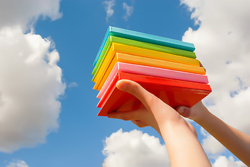 Image showing Hands holding colorful hard cover books