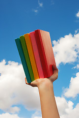 Image showing Hands holding colorful hard cover books