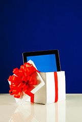 Image showing Tablet PC in a gift box against blue background