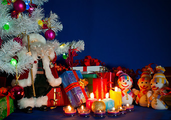 Image showing Three snowmen in front of the Christmas presents and burning can