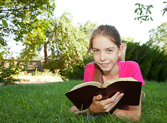Image showing Teen girl reading the Bible outdoors