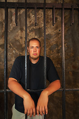 Image showing Young man behind the bars