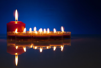 Image showing A lot of burning candles against dark blue background