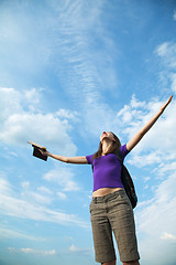 Image showing Young woman staying with raised hands