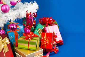 Image showing Heap of the Christmas presents under decorated white evergreen t