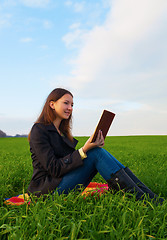 Image showing Teen girl reading the Bible outdoors