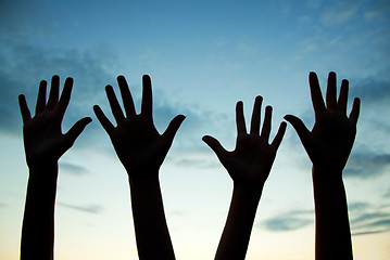 Image showing Four raised hands 