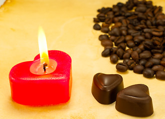 Image showing Burning candle, two heart shaped candies and cofee beans