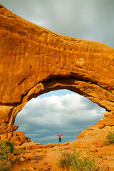 Image showing Woman staying with raised hands inside an Arch