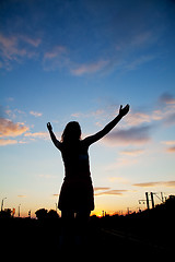 Image showing Woman staying with raised hands