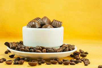 Image showing Cup full with coffee beans and chocolate candies