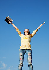 Image showing Young woman staying with raised hands