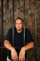 Image showing Young man behind the bars