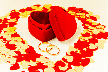 Image showing Two rings in front of a red heart shaped box