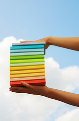 Image showing Hands holding colorful hard cover books