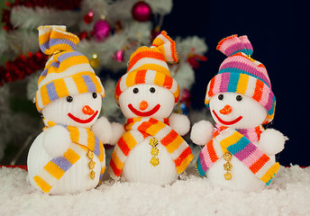 Image showing Three snowmen in front of the decorated white evergreen tree ove