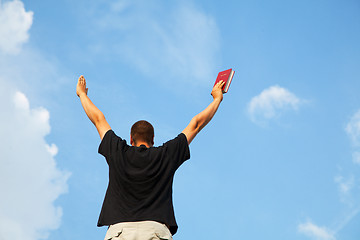 Image showing Young man staying with raised hands