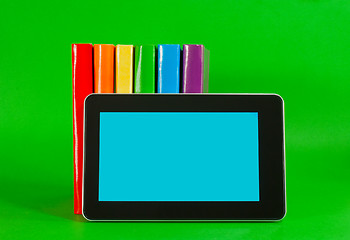 Image showing Row of colorful books and tablet PC