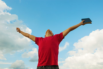 Image showing Young man staying with raised hands