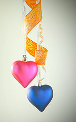 Image showing Two heart shaped toys hanging against light background