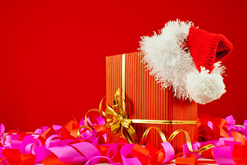 Image showing Christmas present with Santa's hat against red background