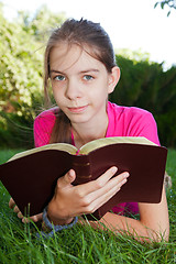 Image showing Teen girl reading the Bible outdoors