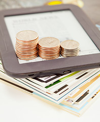 Image showing Electronic book reader with bars of coins