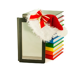 Image showing Electronic book reader wearing Santa's hat with stack of books