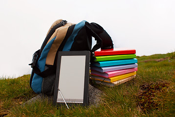 Image showing Stack of colorful books and electronic book reader