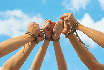 Image showing Three pairs of human hands tied up together