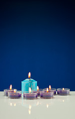 Image showing A lot of burning candles against dark blue background