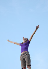 Image showing Young woman sitting with raised hand