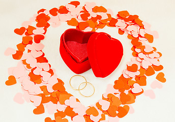 Image showing Two rings in front of a red heart shaped box