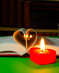 Image showing Open book with burning candle