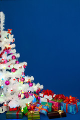 Image showing Heap of the Christmas presents under decorated white evergreen t