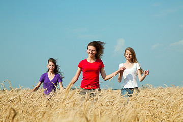 Image showing Teen girls running at the wheat field