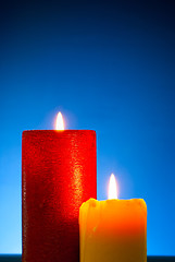 Image showing Five burning colourful candles against blue background