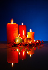Image showing A lot of burning colorful candles against black background