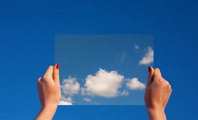 Image showing Hands holding a frame with clouds