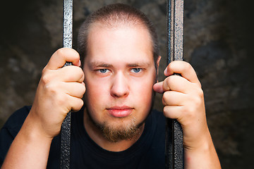 Image showing Young man behind the bars