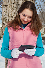 Image showing Teen girl with e-book reader in a park