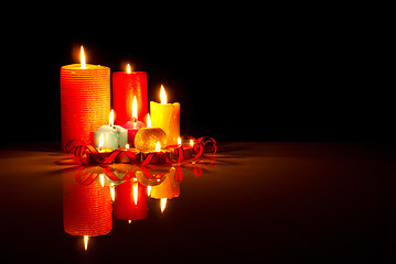 Image showing A lot of burning colorful candles against black background