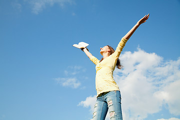 Image showing Young woman staying with raised hands