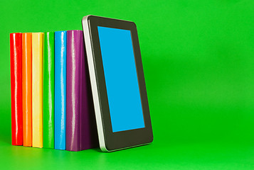 Image showing Row of colorful books and tablet PC