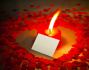 Image showing Burning heart shaped candle and a card